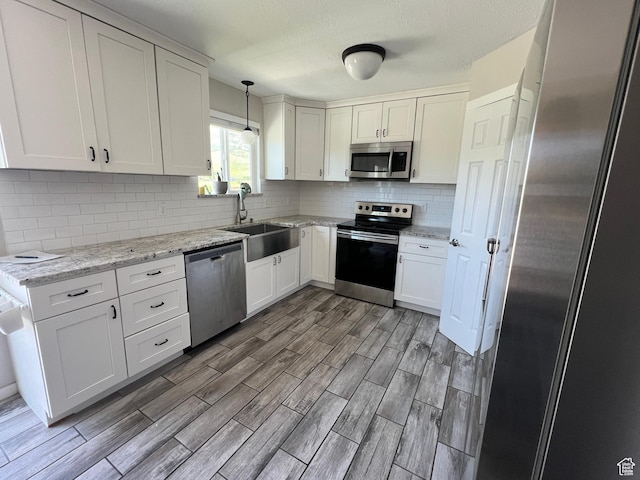 8842 E 500 S, Huntsville, UT 84317 - kitchen with appliances with stainless steel finishes, a sink, light wood finished floors, tasteful backsplash, and white cabinets