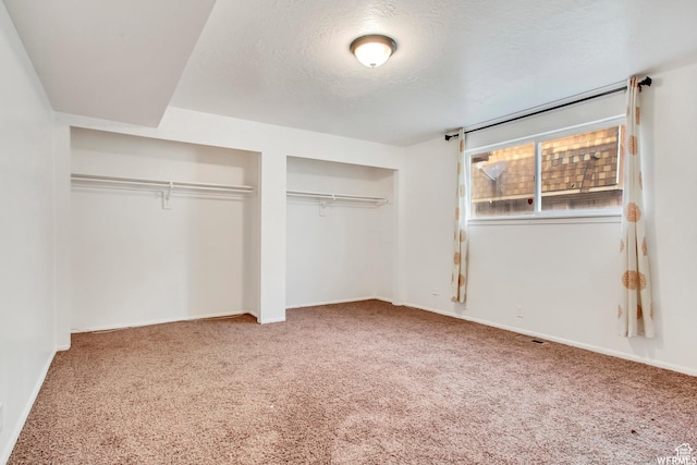 3185 S 4060 W, Salt Lake City, UT 84120 - unfurnished bedroom featuring carpet, multiple closets, a textured ceiling, and baseboards