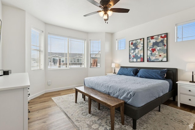 693 W Fireside Ln, Stansbury Park, UT 84074 - bedroom with multiple windows, light wood-style floors, and baseboards