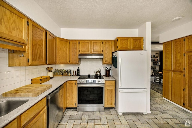55 N 1300 E, Logan, UT 84321 - kitchen featuring appliances with stainless steel finishes, under cabinet range hood, tasteful backsplash, light countertops, and a textured ceiling