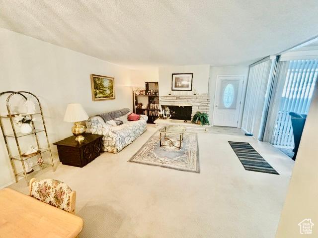 381 W 400 N Unit 12, Bountiful, UT 84010 - living area featuring carpet flooring, healthy amount of natural light, a textured ceiling, and a fireplace with raised hearth