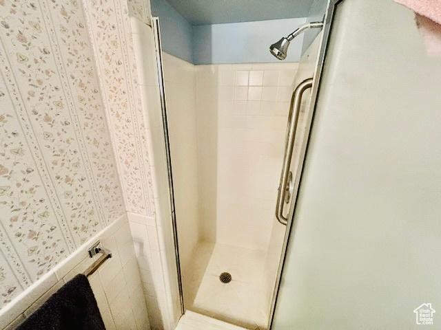 381 W 400 N Unit 12, Bountiful, UT 84010 - bathroom with a stall shower, wallpapered walls, and a wainscoted wall
