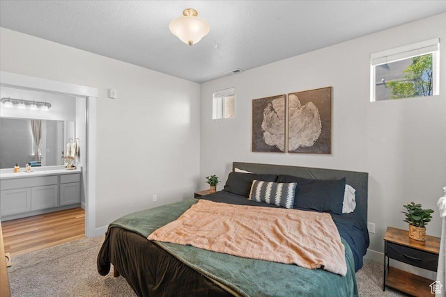 4192 W Mckellen Dr Unit B2, Herriman, UT 84096 - bedroom with a sink, light carpet, ensuite bathroom, baseboards, and light wood-type flooring