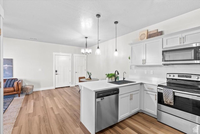 4192 W Mckellen Dr Unit B2, Herriman, UT 84096 - kitchen featuring appliances with stainless steel finishes, a sink, light countertops, a peninsula, and light wood-style floors