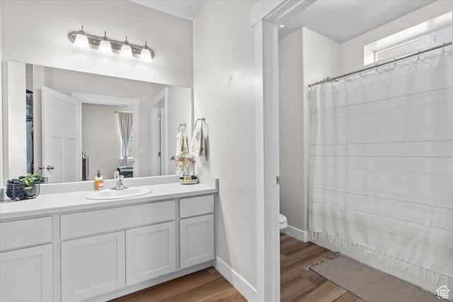 4192 W Mckellen Dr Unit B2, Herriman, UT 84096 - bathroom featuring wood finished floors, vanity, toilet, baseboards, and a shower with curtain