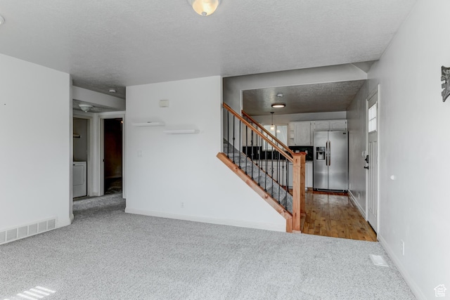 4799 S 3900 W, Roy, UT 84067 - foyer featuring washer / dryer, carpet, stairs, a textured ceiling, and baseboards