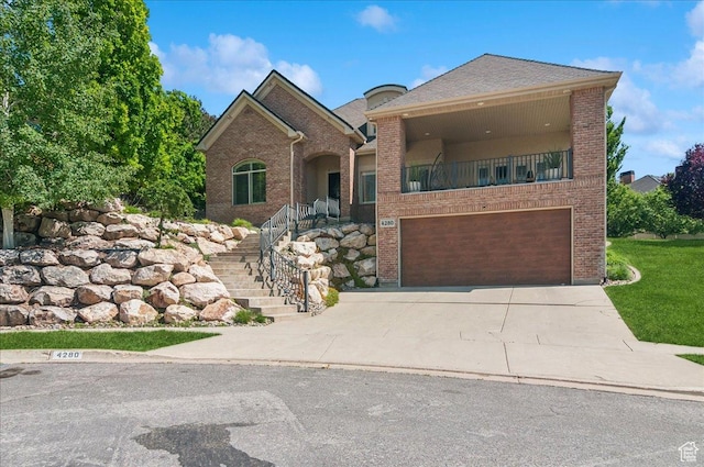 4280 S Scenic Cir E, Bountiful, UT 84010 - view of front of property with brick siding, an attached garage, concrete driveway, a balcony, and stairs