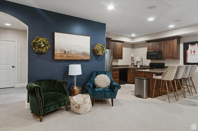 4280 S Scenic Cir E, Bountiful, UT 84010 - kitchen with black appliances, light carpet, a peninsula, a breakfast bar, and arched walkways