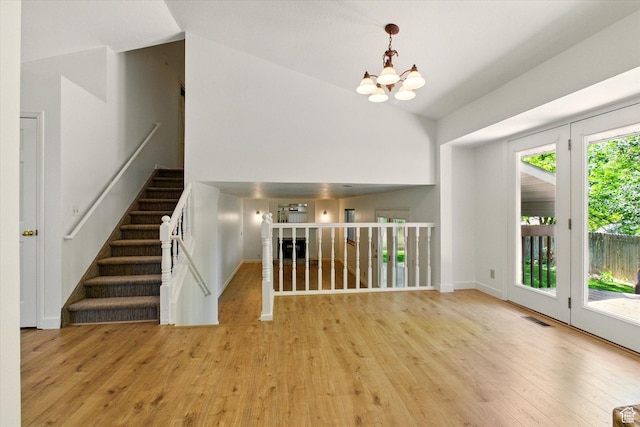 1553 N 1525 E, Logan, UT 84341 - unfurnished living room featuring a chandelier, wood finished floors, baseboards, and high vaulted ceiling