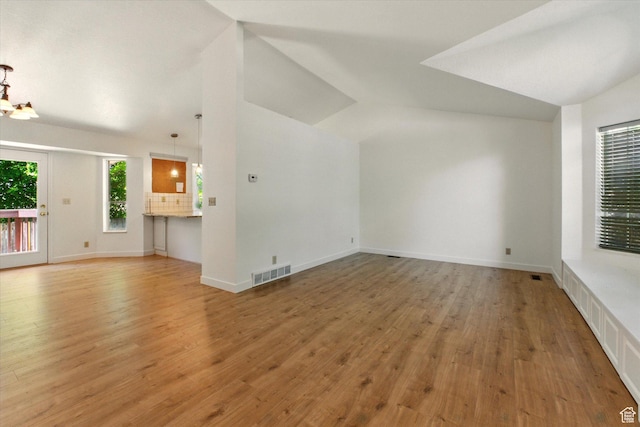 1553 N 1525 E, Logan, UT 84341 - unfurnished living room featuring vaulted ceiling, light wood finished floors, and baseboards