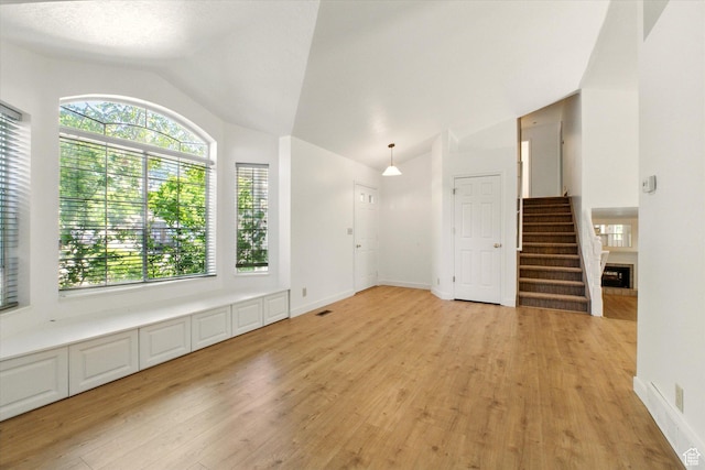 1553 N 1525 E, Logan, UT 84341 - unfurnished room with lofted ceiling, light wood-style flooring, healthy amount of natural light, stairs, and baseboards