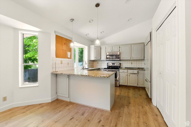 1553 N 1525 E, Logan, UT 84341 - kitchen with appliances with stainless steel finishes, a peninsula, tasteful backsplash, light wood-style floors, and vaulted ceiling