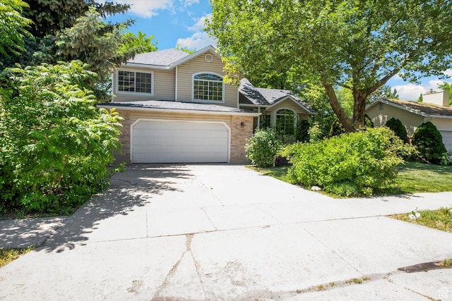 1553 N 1525 E, Logan, UT 84341 - view of front facade featuring driveway, a garage, brick siding, and a shingled roof