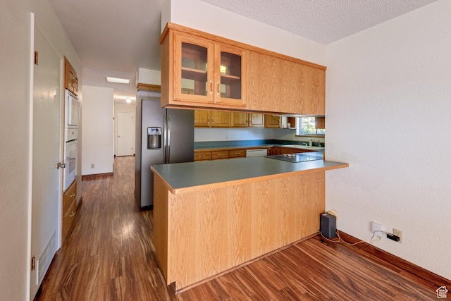 630 N 500 W, Moab, UT 84532 - kitchen featuring stainless steel fridge, dark wood-style floors, a peninsula, glass insert cabinets, and black electric stovetop