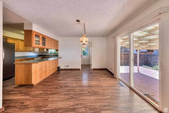 630 N 500 W, Moab, UT 84532 - kitchen with freestanding refrigerator, a peninsula, dark wood-style floors, brown cabinets, and glass insert cabinets