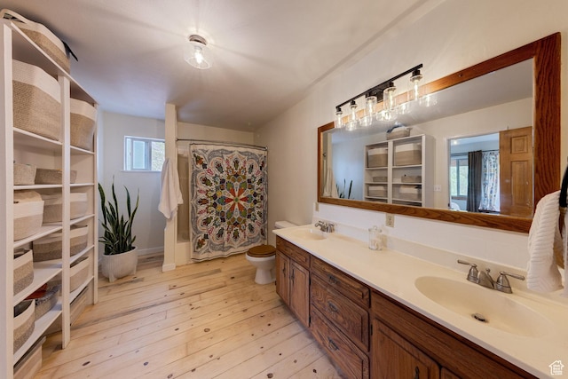 7020 E Creekside Ln, Castle Valley, UT 84532 - full bathroom featuring double vanity, toilet, a shower with shower curtain, and wood finished floors