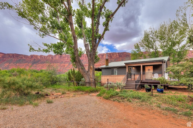 7020 E Creekside Ln, Castle Valley, UT 84532 - rear view of property with a chimney, a porch, and a mountain view