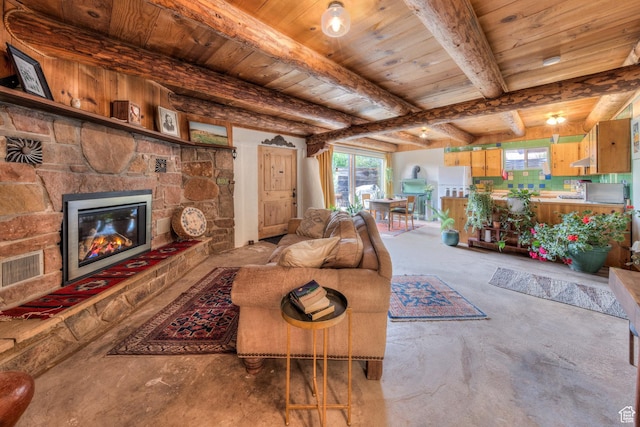 7020 E Creekside Ln, Castle Valley, UT 84532 - living room featuring wood ceiling with exposed beams, unfinished concrete flooring, plenty of natural light, and a stone fireplace