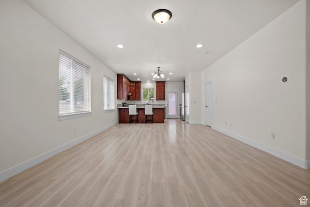 11066 S Becks Ln, South Jordan, UT 84095 - unfurnished living room with baseboards, light wood finished floors, a chandelier, and recessed lighting