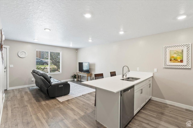 8518 W Cordero Dr, Magna, UT 84044 - kitchen featuring stainless steel dishwasher, a sink, a peninsula, wood finished floors, and open floor plan