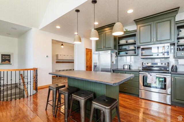 761 S Lakeview Dr, Garden City, UT 84028 - kitchen with appliances with stainless steel finishes, green cabinets, open shelves, dark countertops, and recessed lighting