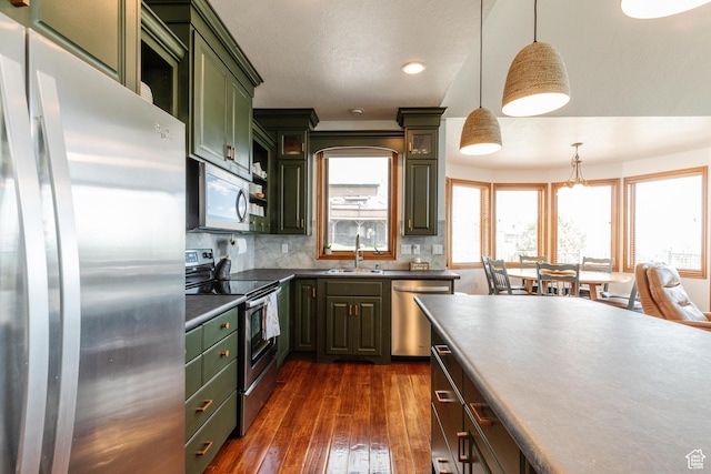 761 S Lakeview Dr, Garden City, UT 84028 - kitchen with appliances with stainless steel finishes, green cabinetry, dark wood-type flooring, decorative backsplash, and a sink