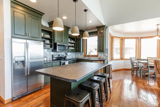 761 S Lakeview Dr, Garden City, UT 84028 - kitchen featuring appliances with stainless steel finishes, green cabinets, open shelves, dark countertops, and baseboards