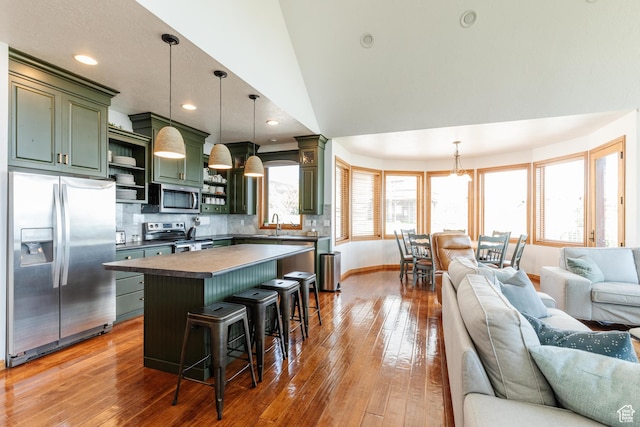 761 S Lakeview Dr, Garden City, UT 84028 - kitchen with stainless steel appliances, green cabinetry, open shelves, open floor plan, and hardwood / wood-style floors
