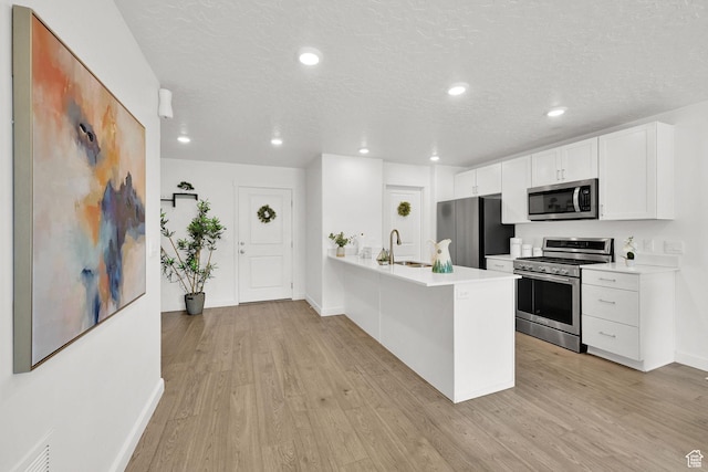 8622 W Cordero Dr S Unit 1170, Magna, UT 84044 - kitchen with appliances with stainless steel finishes, light wood finished floors, baseboards, light countertops, and white cabinets