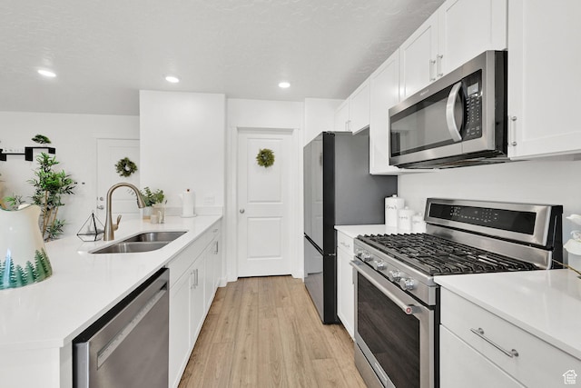 8622 W Cordero Dr S Unit 1170, Magna, UT 84044 - kitchen featuring appliances with stainless steel finishes, a sink, white cabinets, light wood-style flooring, and light countertops