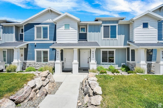 8622 W Cordero Dr S Unit 1170, Magna, UT 84044 - view of front of home with board and batten siding, stone siding, and a front lawn