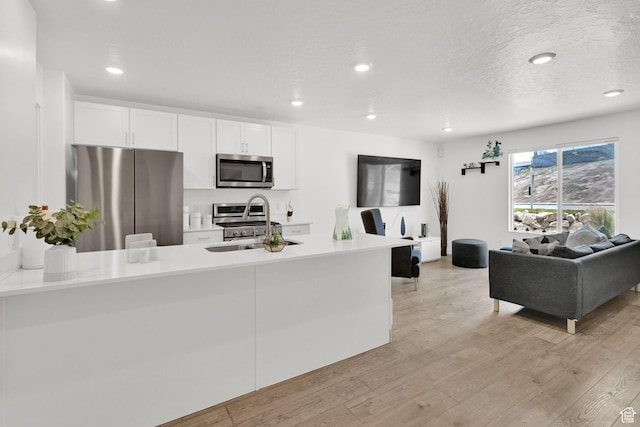 8622 W Cordero Dr S Unit 1170, Magna, UT 84044 - kitchen with appliances with stainless steel finishes, light wood-type flooring, light countertops, white cabinets, and recessed lighting