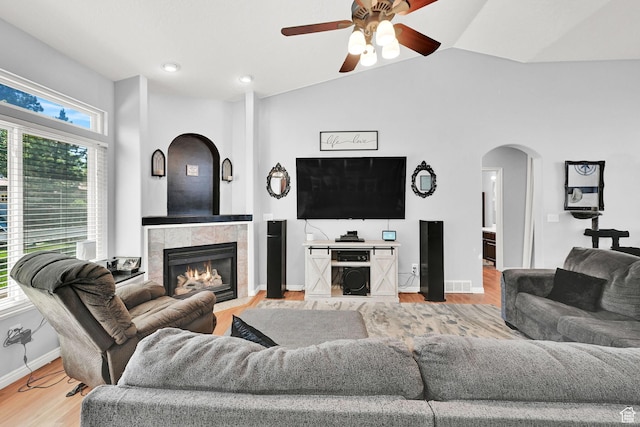 7776 S 2175 E, South Weber, UT 84405 - living room featuring arched walkways, plenty of natural light, ceiling fan, a tiled fireplace, and vaulted ceiling