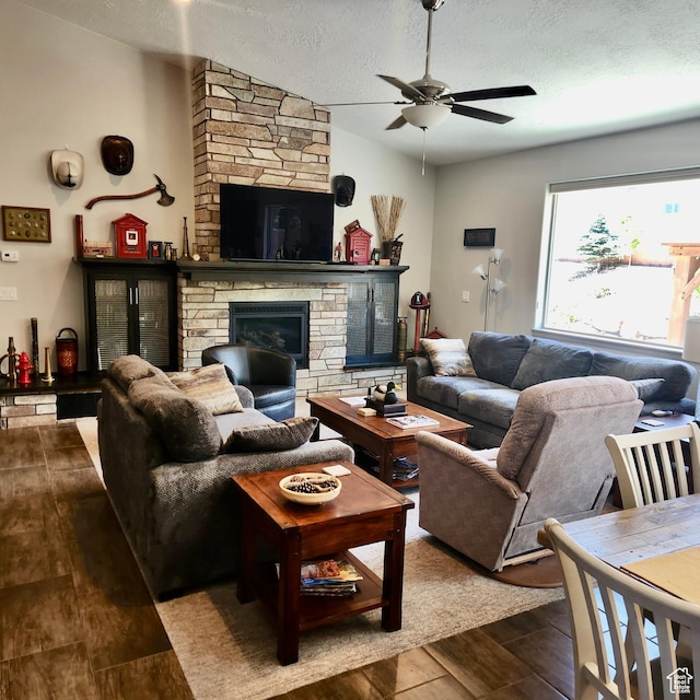 1158 E Ashdown Rd, Cedar City, UT 84721 - living area featuring a ceiling fan, a stone fireplace, a textured ceiling, and dark wood finished floors