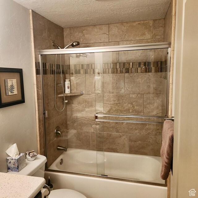 1158 E Ashdown Rd, Cedar City, UT 84721 - bathroom with bath / shower combo with glass door, toilet, a textured ceiling, and vanity
