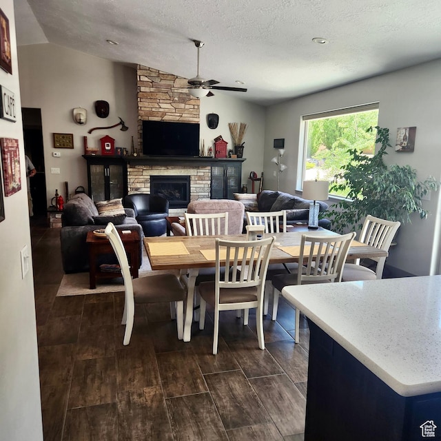1158 E Ashdown Rd, Cedar City, UT 84721 - dining area featuring a ceiling fan, a stone fireplace, lofted ceiling, dark wood-type flooring, and a textured ceiling