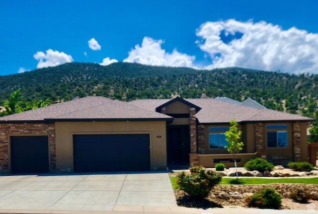 1158 E Ashdown Rd, Cedar City, UT 84721 - prairie-style house featuring a garage, a mountain view, driveway, and stone siding