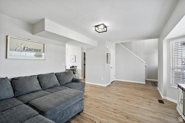 789 W 2005 N, Clinton, UT 84015 - living room featuring light wood finished floors, baseboards, a textured ceiling, and stairs