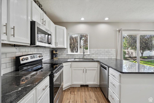 789 W 2005 N, Clinton, UT 84015 - kitchen with stainless steel appliances, a sink, a peninsula, a textured ceiling, and healthy amount of natural light