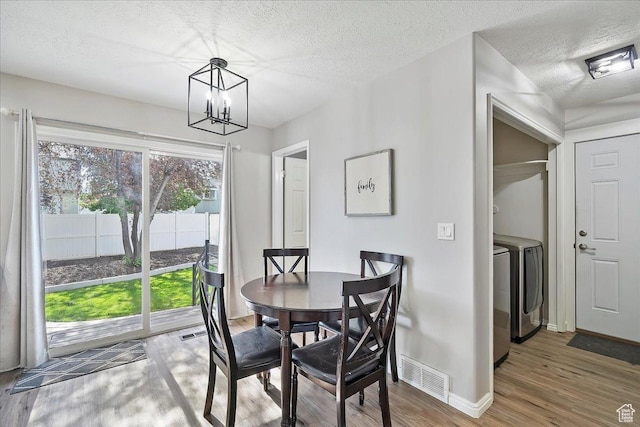 789 W 2005 N, Clinton, UT 84015 - dining area featuring a chandelier, wood finished floors, a textured ceiling, baseboards, and washing machine and clothes dryer