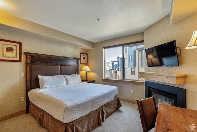 2669 Canyons Resort Dr Unit 308, Park City, UT 84098 - bedroom featuring carpet floors, a glass covered fireplace, a textured wall, and baseboards