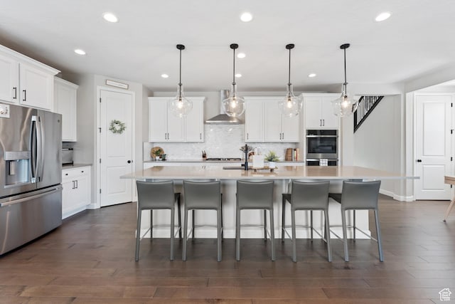 963 W Minuteman Ln, Saratoga Springs, UT 84045 - kitchen with stainless steel appliances, wall chimney exhaust hood, recessed lighting, decorative backsplash, and dark wood finished floors