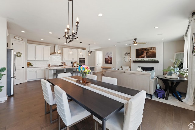 963 W Minuteman Ln, Saratoga Springs, UT 84045 - dining room with a fireplace, dark wood finished floors, ceiling fan, recessed lighting, and a chandelier