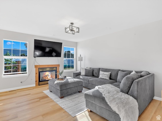 1293 N Buck Run Rd, Rush Valley, UT 84069 - living area with light wood finished floors, baseboards, a glass covered fireplace, and a chandelier