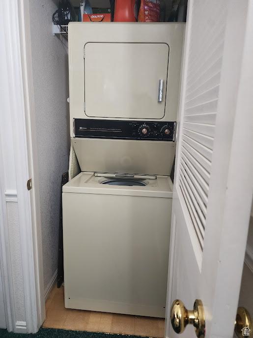 840 N Twin Lakes Dr Unit 127, St George, UT 84770 - laundry room featuring stacked washing machine and dryer, baseboards, and light tile patterned floors