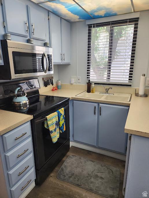 840 N Twin Lakes Dr Unit 127, St George, UT 84770 - kitchen featuring stainless steel microwave, black range with electric stovetop, light countertops, a sink, and blue cabinets