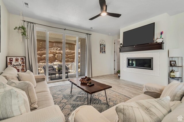 2103 N Elderberry Dr W Unit 222, Saratoga Springs, UT 84045 - living room featuring a ceiling fan, wood finished floors, a brick fireplace, and baseboards