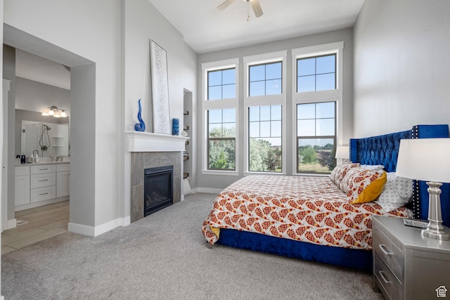 261 E Sage Canal Way, Sandy, UT 84070 - bedroom with carpet, connected bathroom, a tile fireplace, baseboards, and a ceiling fan