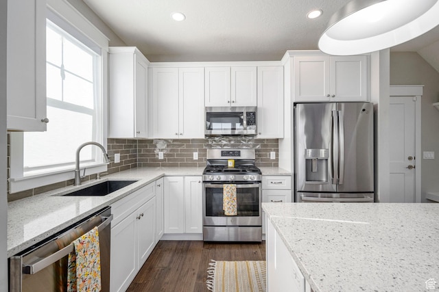261 E Sage Canal Way, Sandy, UT 84070 - kitchen with stainless steel appliances, a sink, white cabinetry, light stone countertops, and dark wood-style floors