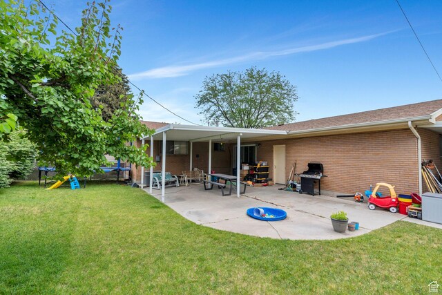 1031 N 1750 W, Provo, UT 84604 - back of property featuring brick siding, a patio, a trampoline, and a yard